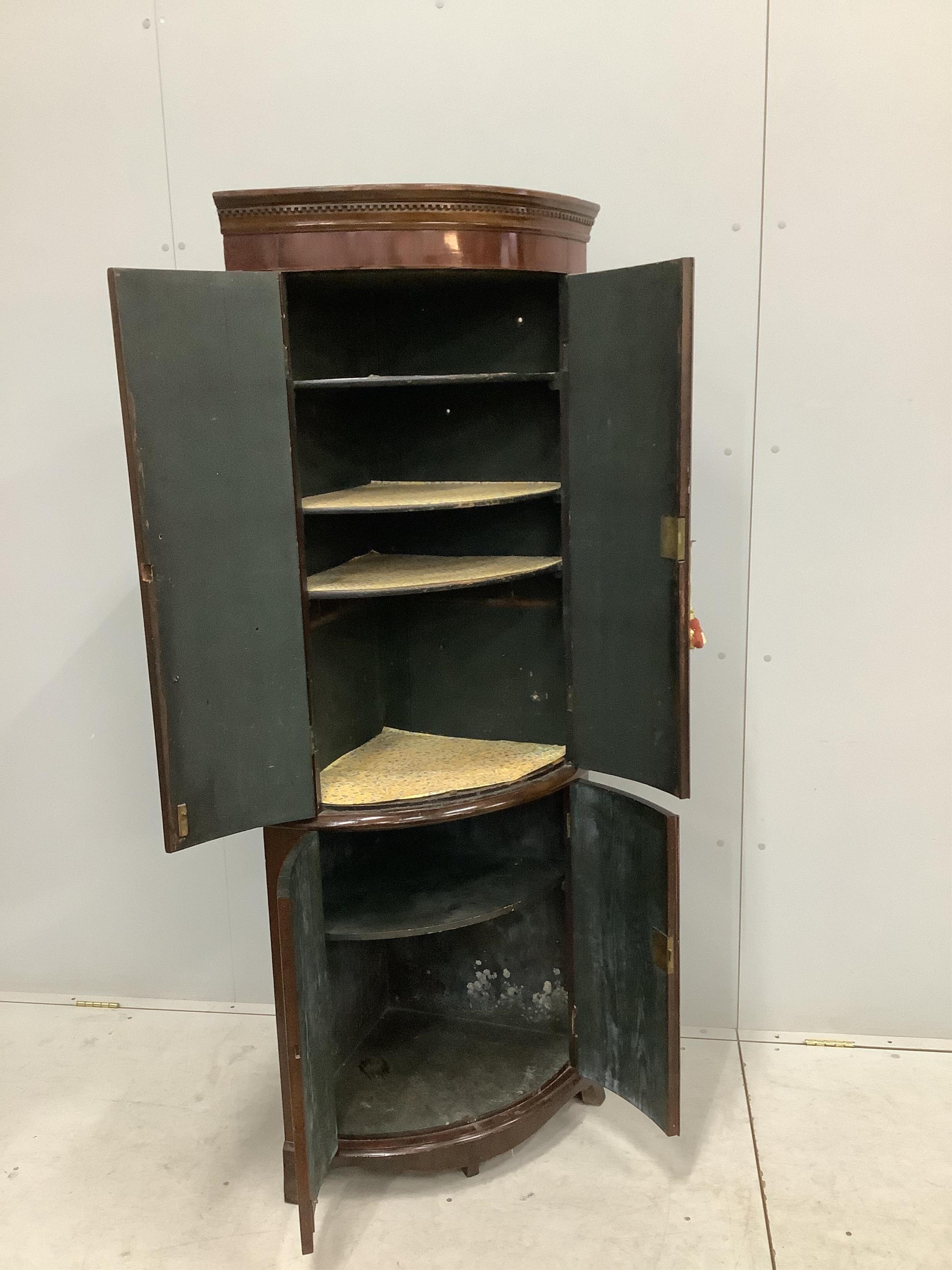 A George III mahogany bow front corner cupboard on later base, width 70cm, depth 46cm, height 179cm. Condition - fair